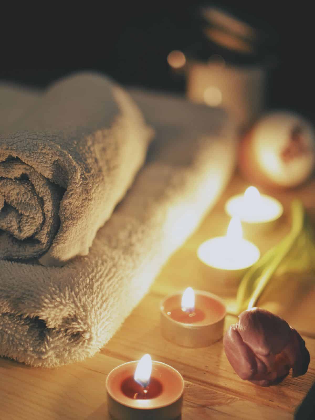 Rolled up towels, candles, and a flower